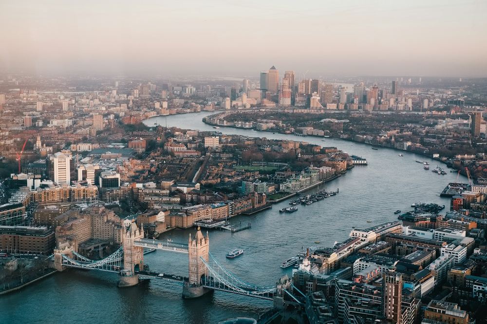 Une ville traversée par un fleuve, vue du ciel dans une lumière douce.